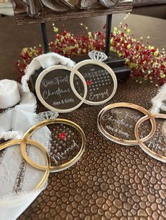 three personalized glass coasters sitting on top of a table next to some flowers