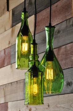 two green glass bottles hanging from a wall