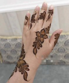 a woman's hand with henna tattoos on it