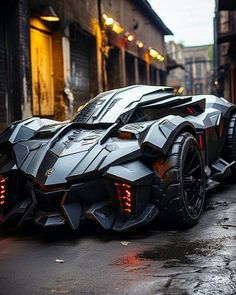 a batmobile parked on the street in front of a building with lights on it