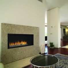 a living room filled with furniture and a fire place next to a wall mounted fireplace