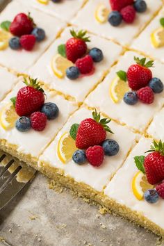 a cake with lemons, blueberries and raspberries on it