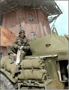 a man sitting on top of an army tank