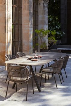 an outdoor dining table with chairs around it