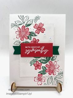 a close up of a card with flowers on it and a red tag hanging from the front