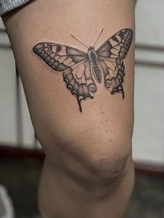 a small butterfly tattoo on the thigh