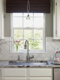 a kitchen sink under a window next to a counter