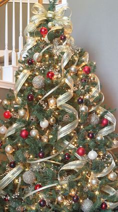 a decorated christmas tree with red, white and gold ornaments