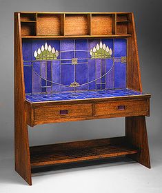 a wooden desk with blue tiles on the top and bottom shelf, in front of a gray background