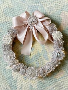 a close up of a wreath with a bow on the top and some beads around it