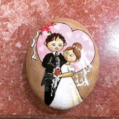 a couple on their wedding day painted on a rock