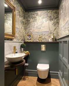 a bathroom with a toilet, sink and mirror in it's wallpapered walls