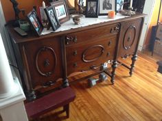 an old dresser with many pictures on it