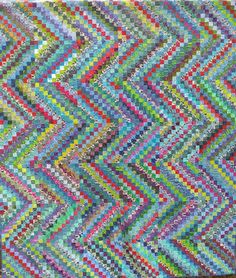 a multicolored quilt is displayed on a table