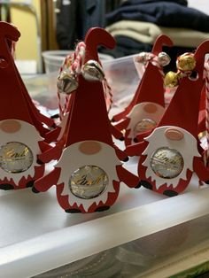 some red and white christmas decorations on top of a table with candy canes in the shape of santa's hats