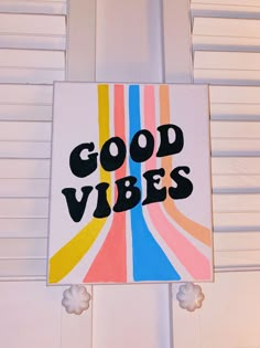 a sign that says good vibes hanging from the side of a door with white shutters