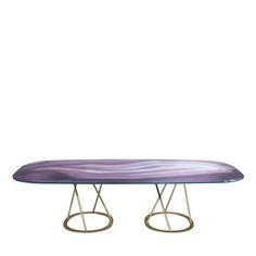 an oval glass table with metal legs and a purple marble design on the top, against a white background