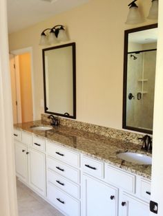 a bathroom with double sinks and two mirrors