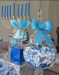 a table topped with blue and white candies next to a candelabra