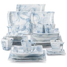 a blue and white marble dinnerware set with matching cups, saucers, and plates