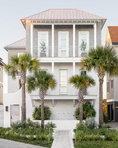 a white house with palm trees in the front yard and walkway leading up to it