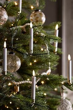 a christmas tree with lit candles and ornaments