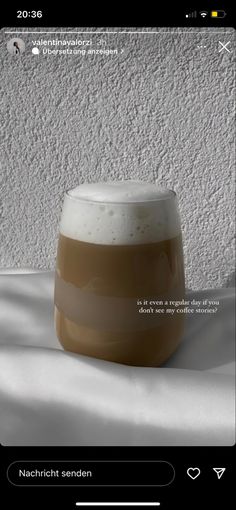 a white and brown cup sitting on top of a table next to a wall with snow