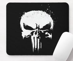 a mouse pad with the image of a skull on it, next to a computer mouse