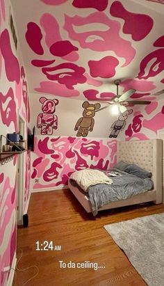 a bedroom with pink camouflage wallpaper and bed in the corner, next to a ceiling fan