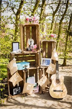 an old wooden crate has been used as a display for guitars and other items in the woods