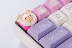 a close up of a purple and white keyboard with a santa clause figure on it