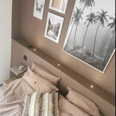 a bed with two pictures hanging on the wall above it and another photo hung over the headboard