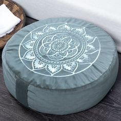 a blue and white round ottoman sitting on top of a wooden floor