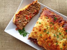 two slices of meatloaf on a white plate with parsley sprig