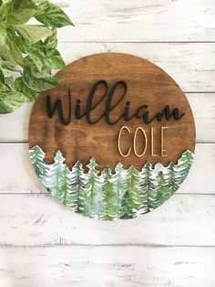 a wooden sign that says, william cole with trees in the background on a white wood wall