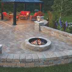 an outdoor fire pit with seating around it