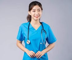 a woman wearing a blue scrub suit with a stethoscope on her chest