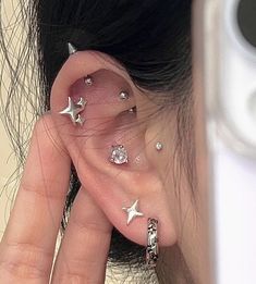 a woman with ear piercings and stars on her ears is taking a selfie