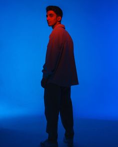 a man standing in front of a blue background with his back turned to the camera