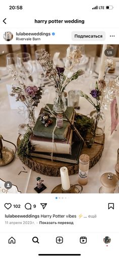 a table topped with books and flowers on top of a white table covered in candles