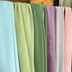 several different colored sheets hanging on a rack