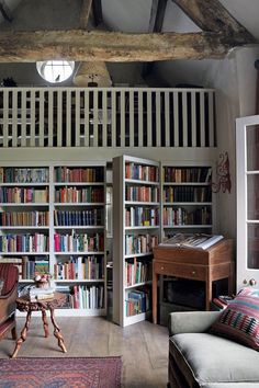 a living room filled with lots of books and furniture