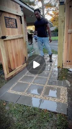 a man standing in front of a wooden door on top of a cement floor next to a