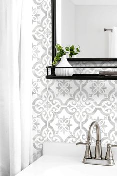 a bathroom sink sitting under a mirror next to a white wall mounted faucet