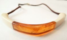 Circa 1970s Two tone plastic choker Pale yellow surrounds marbled amber plastic Color is palest yellow, like butter with a warm clear marbled amber center Strung on chocolate colored silk Spring ring clasp Super condition, light wear to the silk cording only This does not test for amber but does have the look of it. Yellow is a deeper color in person, showing quite light in pictures Please message me if you have any questions or need additional pictures Thanks for looking! Brown Bakelite Jewelry Gift, Brown Bakelite Jewelry As A Gift, Picture Locket, Book Locket, Yellow Necklace, Lipstick Case, Necklace Shop, Chocolate Color, Long Chain Necklace