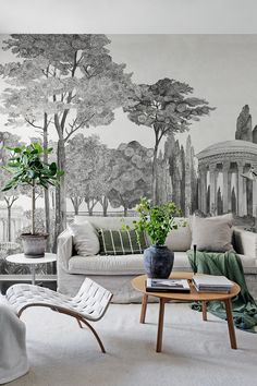 the living room is decorated in black and white with trees on the wall behind it