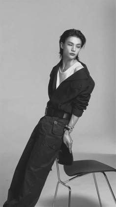 black and white photograph of a woman sitting on a chair with her hands in her pockets