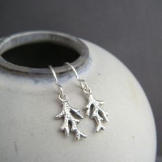 tiny sterling silver coral earrings, 1/2" - Sterling silver 925 charm and sterling ear wires. - Choice of sterling silver hooks or sterling lever backs.  - A tiny solid sterling silver coral branch, measuring 1/4" (7 mm) across, 1/2" (14 mm) down. - Length from top of ear wire to bottom of drop: 1" (2.5 cm).  - The fronts and backs are slightly oxidized (blackened) to bring out the details.   - Sterling silver hooks are a standard 20 gauge (the same size as most "commercial" earrings). - Comes wrapped in a cute silver tin, perfect for gift giving or storage, and includes a silver polish pad and care instructions. Matching necklace: https://www.etsy.com/listing/451777418 More sterling silver coral jewelry: https://www.etsy.com/shop/limegreenmodern?ref=hdr_shop_menu&search_query=coral More o Branch Earrings, Coral Earrings, Coral Jewelry, Themed Jewelry, Beach Jewelry, Matching Necklaces, Last Minute Gifts, Coral, Jewelry Earrings Dangle