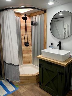 a bathroom with a sink, mirror and shower in it's corner stall area