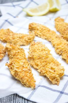 fried chicken strips on a towel with lemon wedges